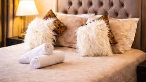A neatly made bed with fluffy pillows, a rolled towel, and a lamp on a bedside table. - Maarif 1BR | Garage + Fast WiFi + Netflix (Dar-el-Beida)