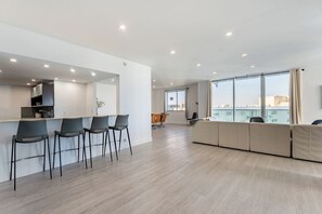 Eine moderne Wohnung mit Küche, Essbereich und Wohnraum, ausgestattet mit großen Fenstern.