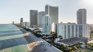 Un paysage urbain côtier avec de hauts immeubles, une plage et un ciel dégagé.