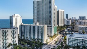 Un grand hôtel à plusieurs étages, doté d’un parking et offrant une vue sur l’océan.