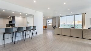 Un appartement moderne doté d’une cuisine, d’un coin repas et d’un espace de vie avec de grandes fenêtres.