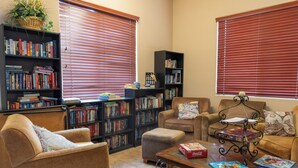 A cozy living room with two sofas, a coffee table, and two bookshelves filled with books. - Cozy 2-Bedroom Condo with Mountain View, Hot tub and Heated Pools (Mesa)