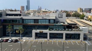 Un bâtiment moderne doté d’un parking, d’un panneau indiquant l’interdiction d’accès et offrant une vue sur le panorama urbain.