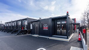 A modern hotel with a black exterior, multiple rooms, and a visible entrance. - HOTEL R9 The Yard Ryugasaki (Ryugasaki)