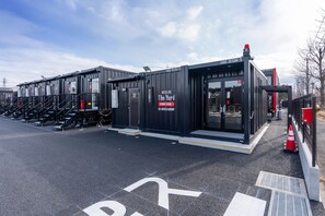 A modern hotel with a black exterior, multiple rooms, and a visible entrance.