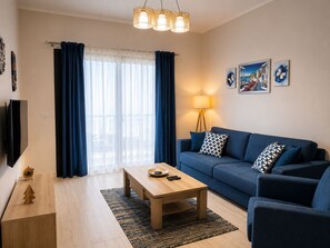 Ein Wohnzimmer mit einer Couch, einem Couchtisch und einem Fernseher.