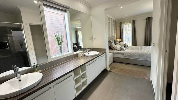 A modern bathroom with two sinks, a large mirror, and a window. - Modern Family Haven | Spacious 4BR + Media Room (Tarneit)
