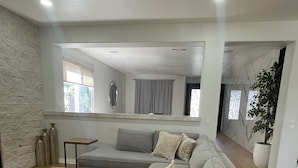A modern living room with a grey sofa, a wooden coffee table, and a patterned rug. - Enjoyable 4-bedroom house with a beautiful rock water fall slide swimming pool. (Ontario)