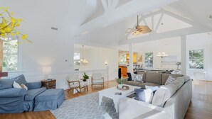 Ein geräumiges Wohnzimmer mit Sofa, Couchtisch und einem Essbereich mit Stühlen.
