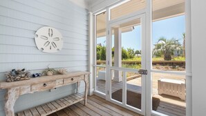 A wooden deck with a rustic bench and a wall-mounted decorative piece. - VIEWS of the Atlantic will mesmerize you from The Glass Slipper (Bald Head Island)