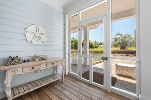 A wooden deck with a rustic bench and a wall-mounted decorative piece. - VIEWS of the Atlantic will mesmerize you from The Glass Slipper (Bald Head Island)
