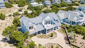 A large, light blue house with multiple levels and a spacious deck area. - VIEWS of the Atlantic will mesmerize you from The Glass Slipper (Bald Head Island)