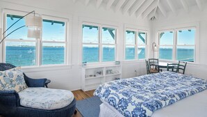 A room with a bed, a chair, a table, and a view of the sea. - Welcome to one of the Island (Bald Head Island)