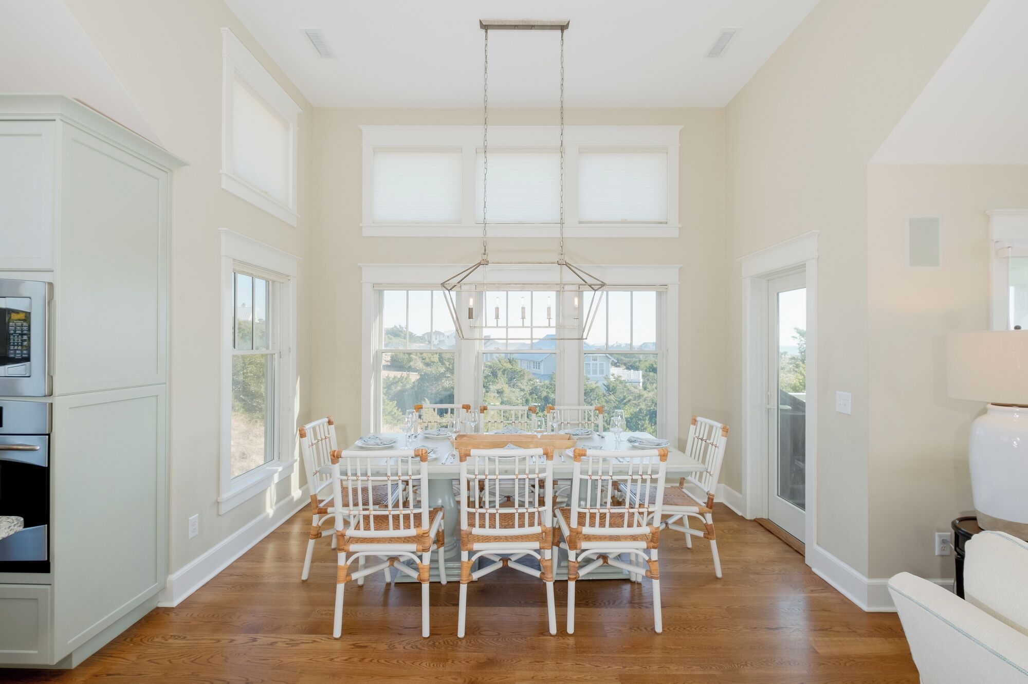 Un comedor amplio con una gran mesa y sillas, ventanas grandes y vistas al exterior.