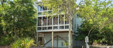 A two-story building with large windows and a wooden deck.