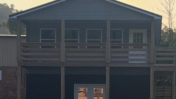 A two-story building with a front entrance and a small porch. - Spacious home w/dual entrance for added privacy. Near HMT system, dining & shops (Logan)