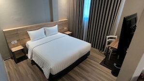 A modern hotel room with a large bed, a bedside table, a chair, and a desk. - STAY KERTAPATI HOTEL (Palembang)