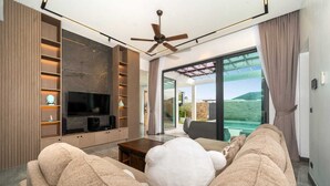 Ein modernes Wohnzimmer mit Flachbildfernseher, Einbauschränken und einem großen Fenster mit Blick auf eine schöne Landschaft.