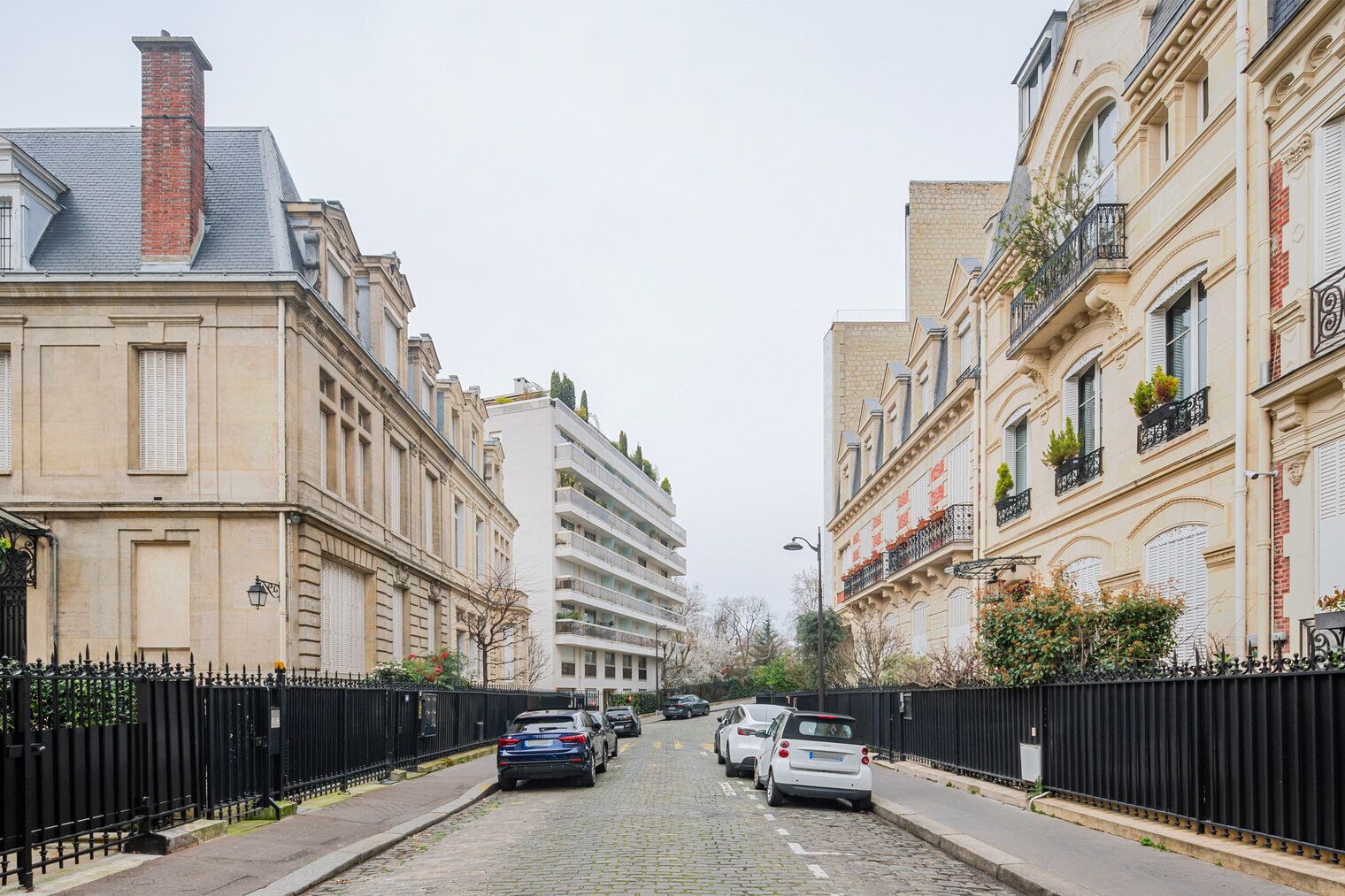A cobblestone street lined with historic buildings, featuring a mix of residential and commercial properties.