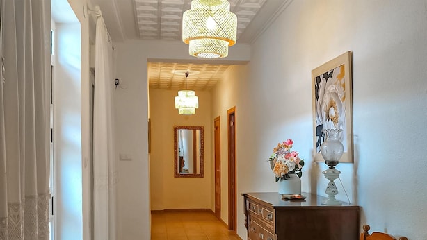 A hallway with a wooden dresser, a mirror, a vase with flowers, and a hanging light fixture. - House in Banyeres de Mariola (Banyeres de Mariola)