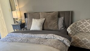 A bedroom with a bed, a nightstand, a lamp, and a patterned rug. - Broadmoor Guest Mother-in-Law Suite (Colorado Springs)
