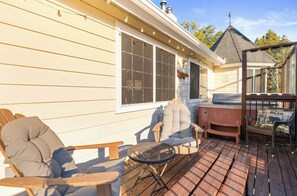 A wooden deck with outdoor seating, including a chair and a table. - Private hot tub, Gorgeous views, Just minutes from the ski resorts & Lake (Big Bear Lake)