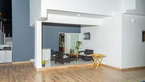 Ein modernes Wohnzimmer mit einer Sofagarnitur, einem Couchtisch und einem an der Wand befestigten Fernseher.
