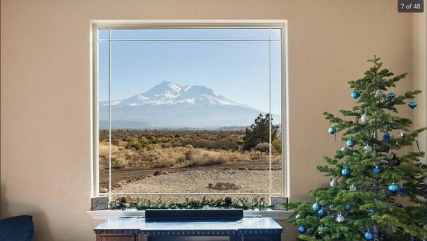 Een televisie bevestigd aan een houten kast, met een kerstboom ernaast.