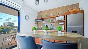 Uma cozinha moderna com uma ilha grande, eletrodomésticos embutidos e plantas em vasos.