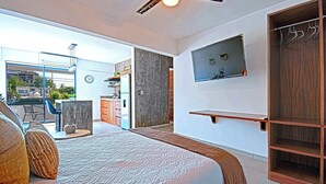 Quarto moderno com uma cama grande, televisão na parede e guarda-roupa de madeira.
