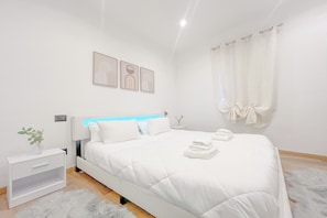 Ein modernes Schlafzimmer mit Bett, Nachttisch und Wandbild.