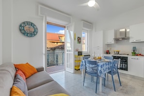 Ein modernes Apartment mit Küche, Essbereich und einem Balkon.