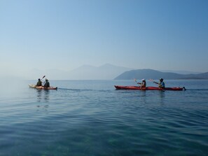 Deux kayaks sur une étendue d’eau calme, avec des montagnes en arrière-plan.