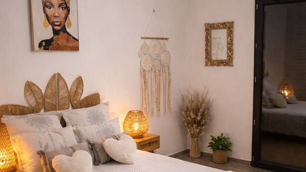 Un dormitorio con una cama grande, lámparas de noche, un tapiz en la pared y un espejo.