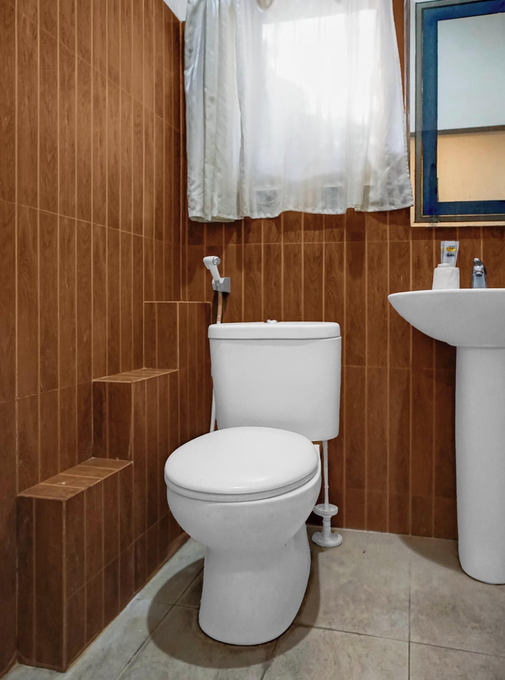 A bathroom with a white toilet, a sink, and a shower area.