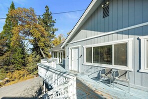 A two-story house with a porch, a covered entryway, and a visible garage door. - Mountain Retreat–Steps To Bear Mountain Ski (Big Bear Lake)