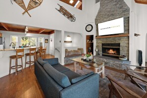 A spacious living area with a stone fireplace, a sofa, and a dining table.