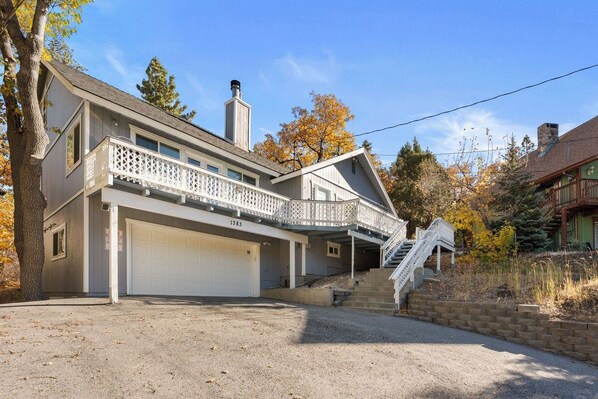 A two-story house with a covered front porch, a garage, and a staircase leading to the upper level.