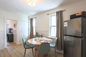 A compact kitchen with a dining table, chairs, a refrigerator, and a microwave. - Newly Updated, Stylish Unit Close to the Lake&Hospitals (Cleveland)