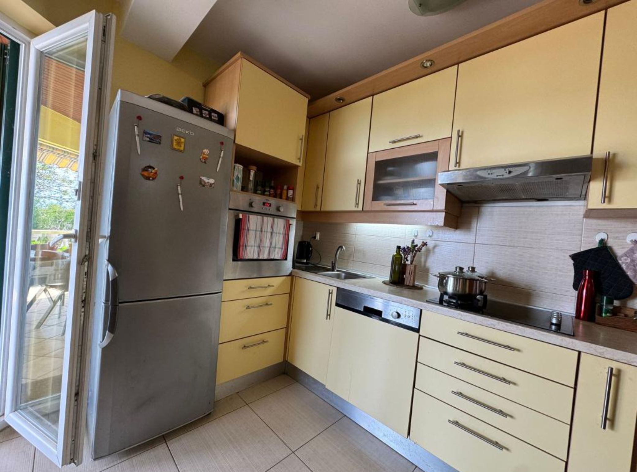A compact kitchen with a refrigerator, oven, microwave, and dishwasher.