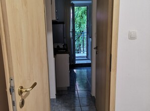 A hallway leading to a balcony with a view of greenery. - Apartments Boris-ivan (Marina)