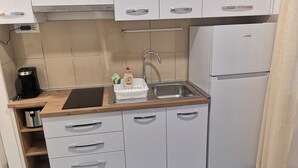 A compact kitchen with a sink, a coffee maker, and a refrigerator. - Apartments Boris-ivan (Marina)