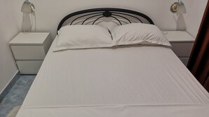 A bed with white bedding, two bedside tables, and a wall-mounted lamp. - Apartments Boris-ivan (Marina)