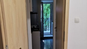 A hallway leading to a balcony with a view of greenery. - Apartments Boris-ivan (Marina)