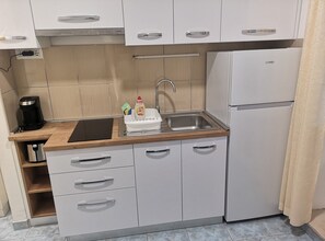 A compact kitchen with a sink, a coffee maker, and a refrigerator. - Apartments Boris-ivan (Marina)