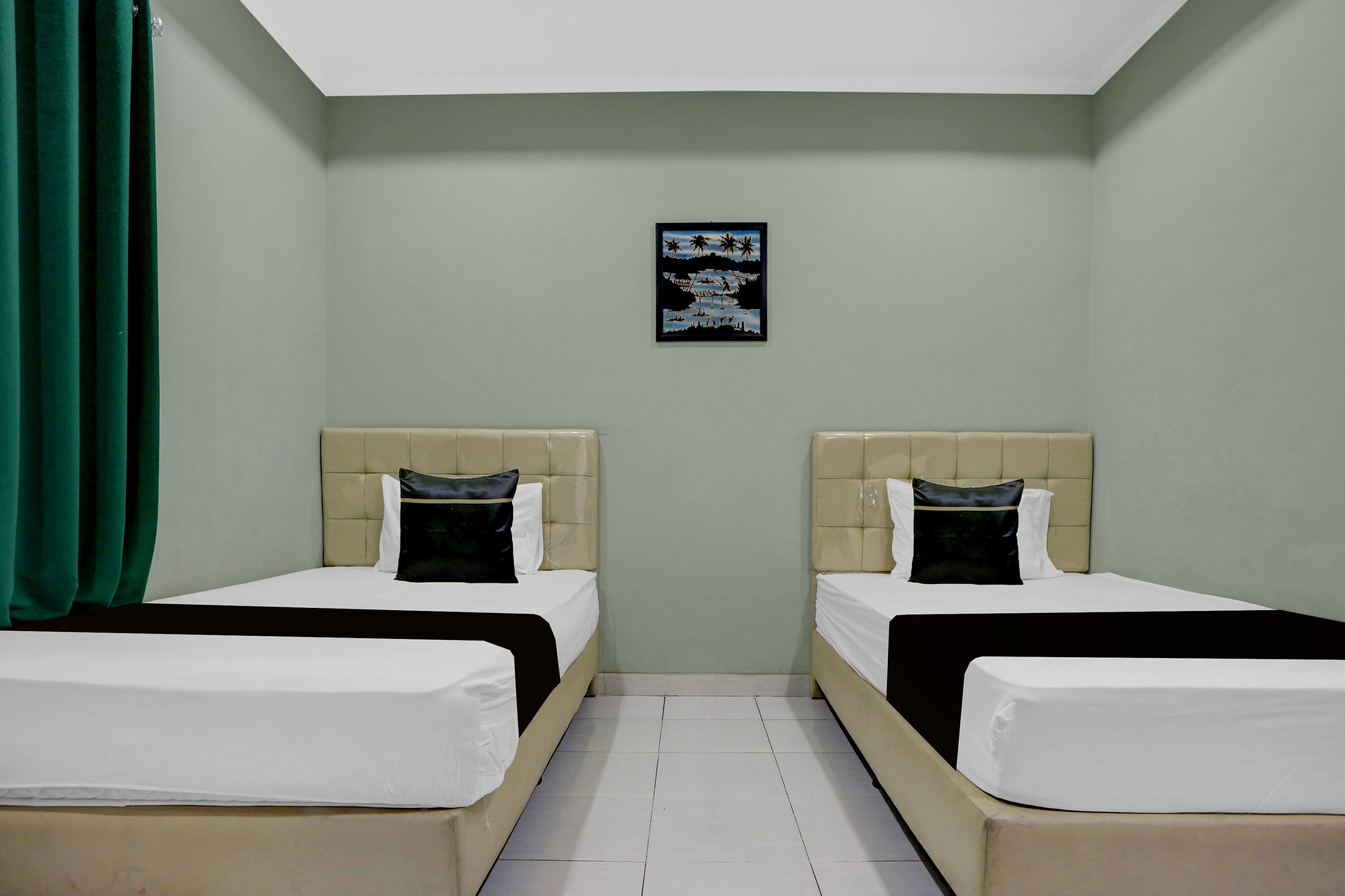 Habitación de hotel con dos camas, una cortina verde, una obra de arte en la pared y suelo de baldosas.