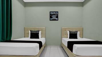 Habitación de hotel con dos camas, una cortina verde, una obra de arte en la pared y suelo de baldosas.