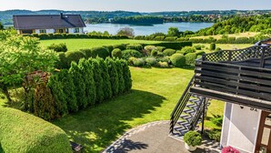 Un jardin bien entretenu, avec des haies soigneusement taillées et une vue sur un lac.