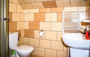 A bathroom with a toilet, sink, and towel rack. - Amazing apartment in Chmielno with lake view (Chmielno)