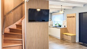 A modern kitchen with wooden accents, a built-in stove, and a bench. - Cozy home in Zuromino with WiFi (Zuromino)